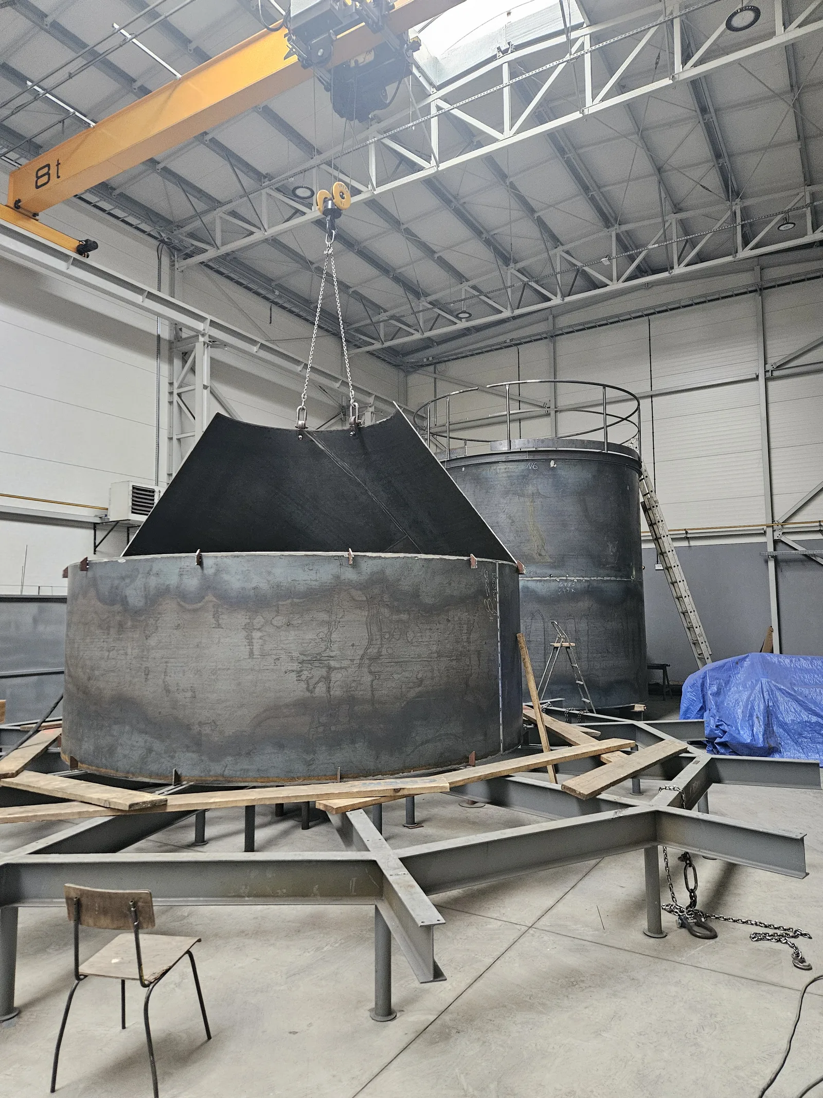 Vessel shell lifted by crane during assembly
